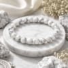natural-howlite-bracelet-premium-product-display Premium Natural Howlite Bracelet with glossy white 8mm beads and natural grey veining on a luxury white marble background.