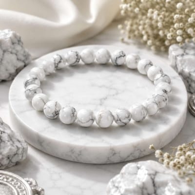 Premium Natural Howlite Bracelet with glossy white 8mm beads and natural grey veining on a luxury white marble background.