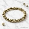 Luxury product photo of Natural Pyrite Bracelet on white marble background with premium polished metallic finish.