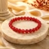 Natural Lal Hakik (Red Agate) bracelet with polished semi-transparent 8mm gemstone beads isolated on a pure white background.
