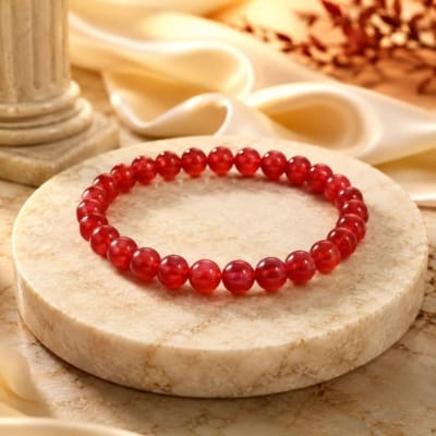 Natural Lal Hakik (Red Agate) bracelet with polished semi-transparent 8mm gemstone beads isolated on a pure white background.